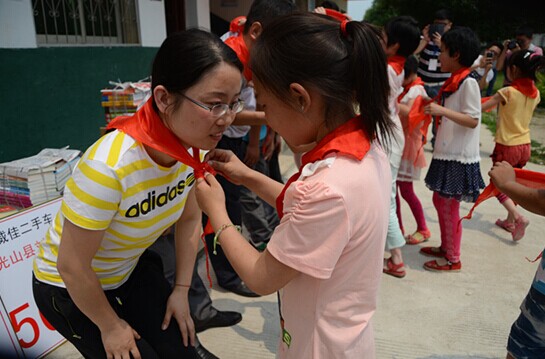 捐贈(zèng)儀式上，孩子們?yōu)閻?ài)心天使系上紅領(lǐng)巾