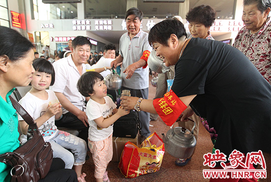 老年雷鋒團”志愿者在候車廳為旅客送水。