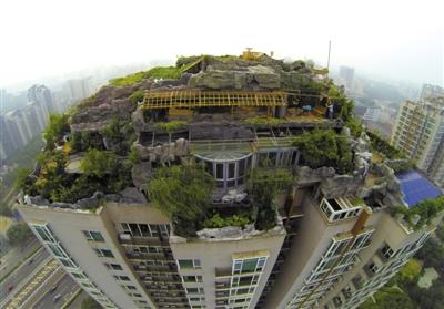 　　昨日，身穿橘黃色馬甲的工作人員在人濟山莊樓頂拆除違章建筑。新京報記者 吳江 攝