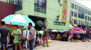 金壇市實(shí)驗(yàn)幼兒園門(mén)前，家長(zhǎng)在排隊(duì)