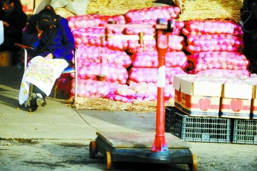 水果批發(fā)市場(chǎng)內(nèi)，沒(méi)有客戶(hù)時(shí)，商戶(hù)在繡十字繡