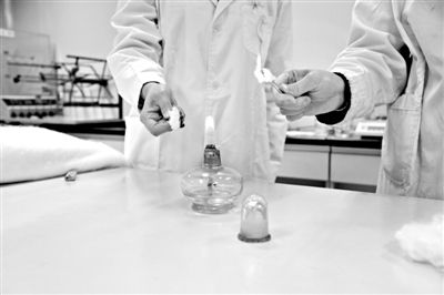 實驗人員操作的燃燒檢測法中，真蠶絲離開火焰就熄滅(左)。