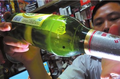 這瓶未開(kāi)封的燕京啤酒內(nèi)有一顆黑色懸浮物。京華時(shí)報(bào)記者 徐曉帆 攝
