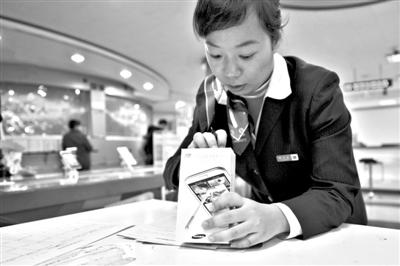 11月6日，北京移動(dòng)西直門(mén)營(yíng)業(yè)廳的工作人員在為顧客購(gòu)買(mǎi)的4G手機(jī)登記。新華社發(fā)