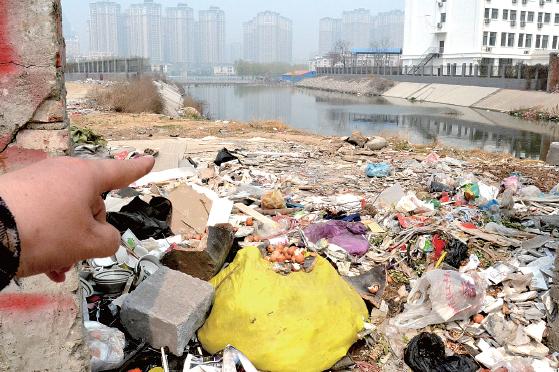 金水河長江路橋下河水發(fā)臭，水邊堆放眾多垃圾