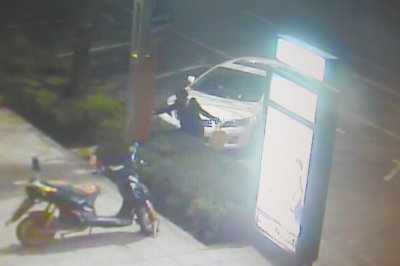 監(jiān)控視頻顯示，一名女子正在往路燈桿和路牌燈箱上噴涂。