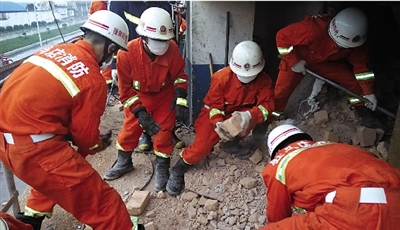 消防人員在清理熔鹽爐倒塌的廢墟。