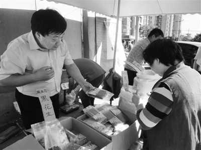 昨日，河南企業(yè)家劉春喜在京“練攤”，為顧客挑選綠豆。新京報記者 張玉學(xué) 攝