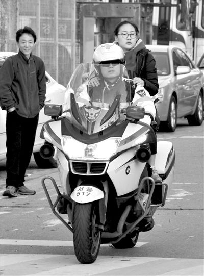 7日，首爾，警察將一名考生送抵考場。新華社發(fā)