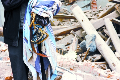 老人手中拿著曾控制住他的電線、床單