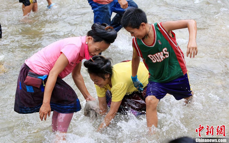 7月9日，村民在小河里摸魚(yú)搶魚(yú)。譚凱興 攝