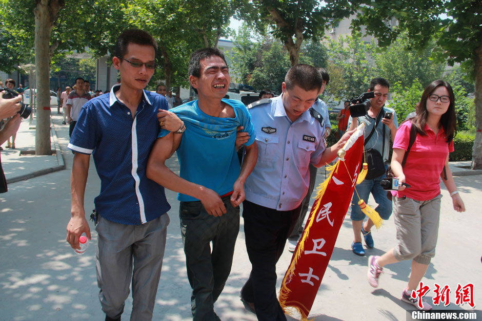 圖為獲救嬰兒父親情緒一度失控，當(dāng)?shù)鼐焦ぷ魅藛T對其進(jìn)行攙扶。張一辰 攝