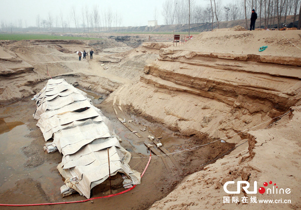 2014年1月6日，河南洛陽古沉船發(fā)掘現(xiàn)場，近日有雨雪天，考古人員給古沉船披上一層“雨衣”。