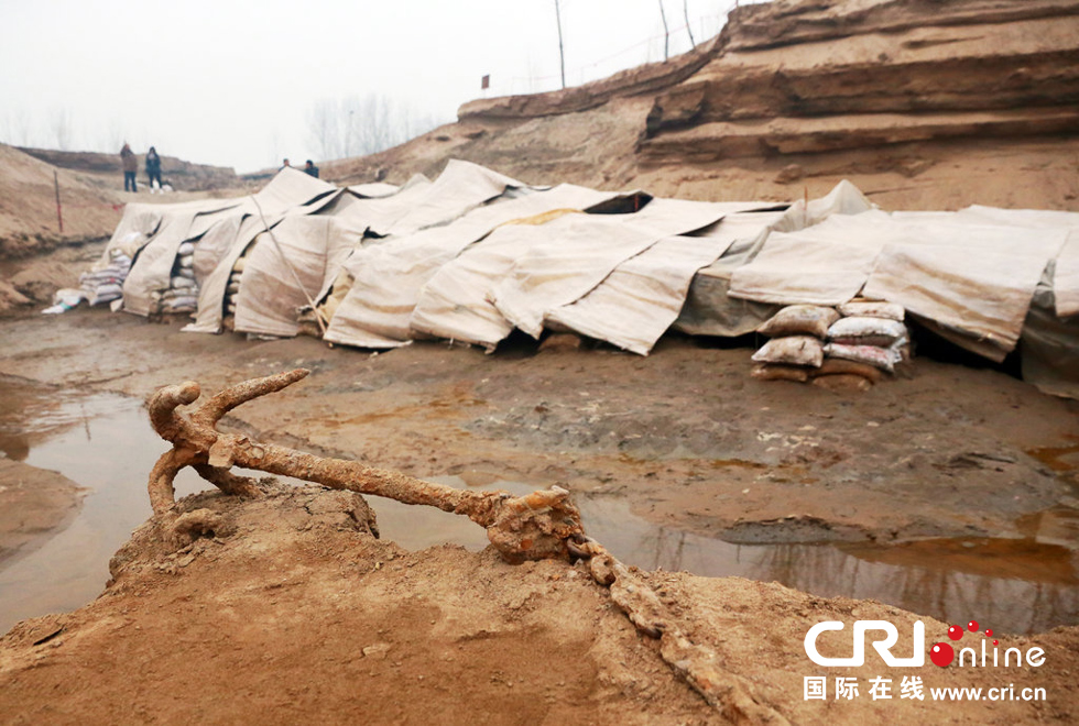 2014年1月6日，河南洛陽古沉船發(fā)掘現(xiàn)場，古沉船鐵錨從見天日，靜靜地躺在古船旁。
