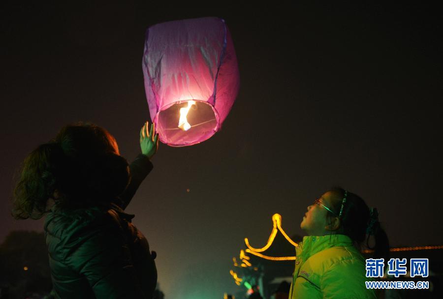 　1月30日，游客在江蘇省鎮(zhèn)江市金山公園門口放飛孔明燈。