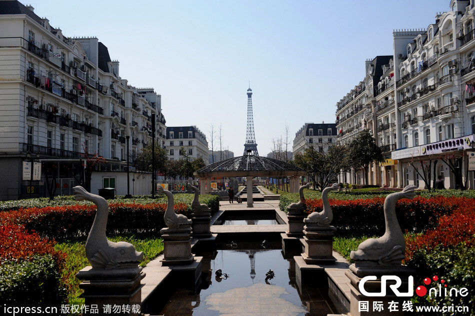 　2014年3月21日，杭州天都城，農(nóng)民在山寨埃菲爾鐵塔下耕作。圖片來(lái)源：東方IC