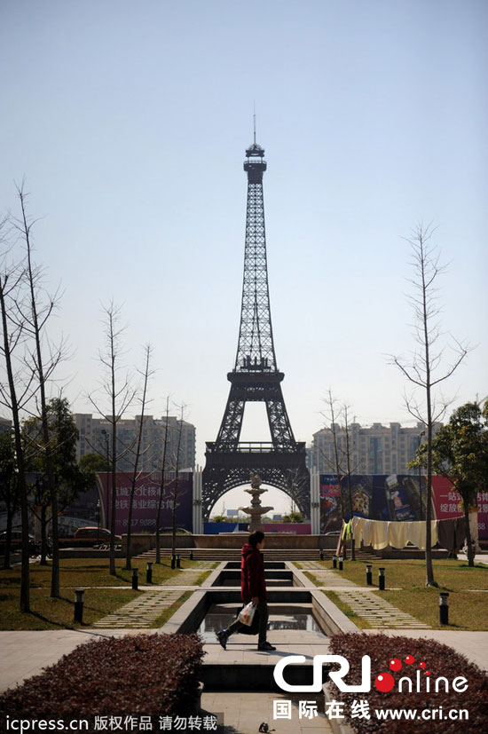 　2014年3月21日，杭州天都城，農(nóng)民在山寨埃菲爾鐵塔下耕作。圖片來(lái)源：東方IC