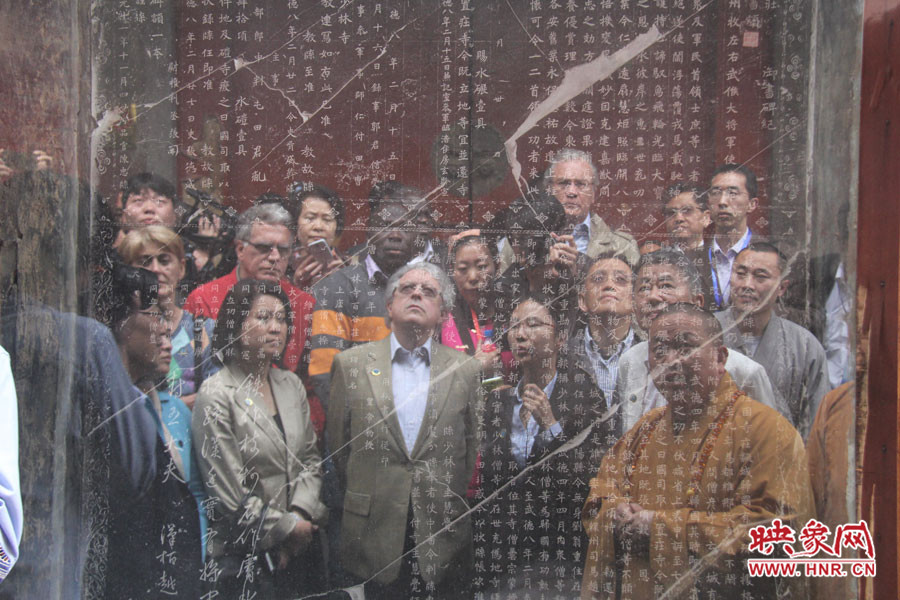 在一塊石碑前，少林寺方丈正在講解