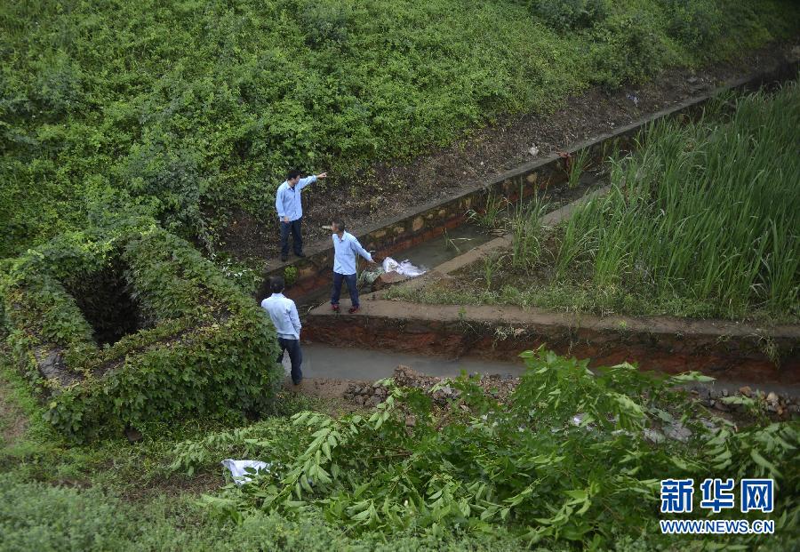 5月18日，工作人員在槽罐車泄漏現(xiàn)場附近的水渠邊查看情況。