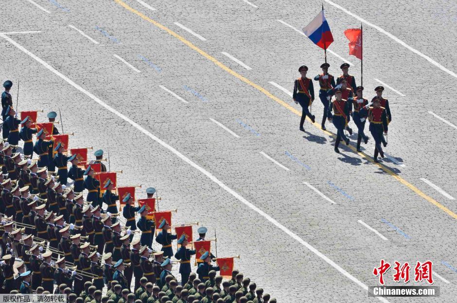 圖為俄羅斯國(guó)旗從受閱部隊(duì)前經(jīng)過(guò)。
