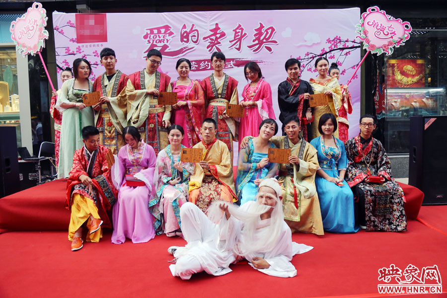 現(xiàn)場8對兒年輕男女舉起“賣身契”集體拍照。