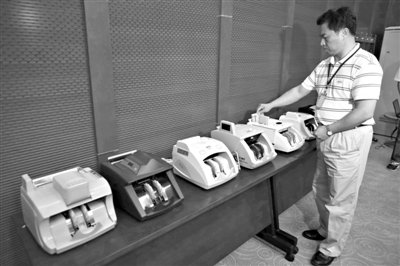 昨日，央行工作人員用各種驗(yàn)鈔機(jī)對(duì)C1F9假幣進(jìn)行測(cè)試，機(jī)器均能及時(shí)作出異常報(bào)警反應(yīng)。新京報(bào)記者 浦