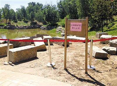 圓明園規(guī)月橋橋體構(gòu)件區(qū)域的警戒線和提示牌。 新京報(bào)記者 鄧琦 攝