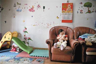 6月14日，未婚媽媽于軍的家里。女兒悅悅抱著兔子玩偶，在聽媽媽手機(jī)上的兒歌，這個4歲女孩喜歡兔子。