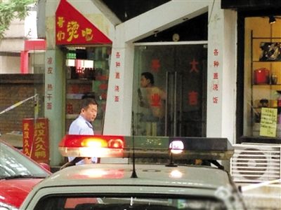 闖入面館的持刀男子與趕來的民警隔著玻璃門對峙，后店內(nèi)一名女童被其劫持。網(wǎng)友供圖