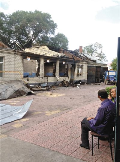 7月27日，海倫聯(lián)合敬老院內(nèi)，幾名老人看著對(duì)面被燒毀的特護(hù)病房。新京報(bào)記者 涂重航 攝