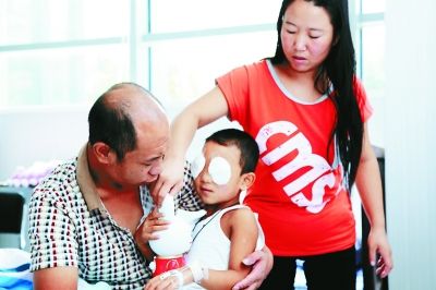 斌斌手術后第一天恢復良好，斌斌父母在用玩具逗他開心供圖/嚴益