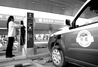 9月11日，懷柔區(qū)，電動(dòng)出租車司機(jī)正在為車輛充電。