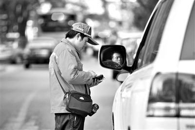 10月15日，朝陽(yáng)區(qū)東大橋路，停車(chē)管理員從腰間掏出一個(gè)專(zhuān)用POS機(jī)，正在錄入停車(chē)信息。新京報(bào)記者 周崗峰 攝