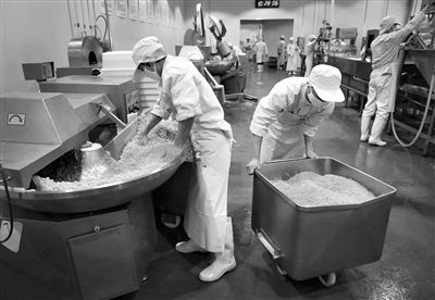 昨日，位于順義李遂開發(fā)區(qū)的慶豐包子鋪配送中心生產(chǎn)車間，工人們正在斬拌胡蘿卜餡料。