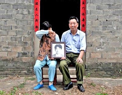 江蘇鎮(zhèn)江，老劉夫婦捧著獨(dú)生子的遺像在老家前留影南方都市報(bào)供圖L