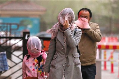 昨日下午，朝陽(yáng)區(qū)豆各莊，行人將紗巾裹在頭上防沙塵。