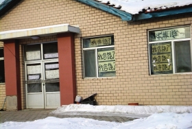 伊春市帶嶺區(qū)一排破舊的平房，房間窗戶上貼滿了“我告饒了”的字樣。