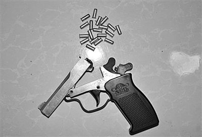 警方從搶劫嫌疑人處起獲的贓款和發(fā)令槍、子彈。警方供圖