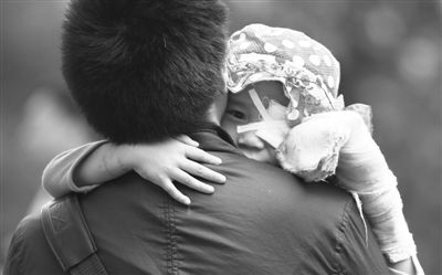 昨日，北京同仁醫(yī)院，被砍傷的彤彤趴在舅舅的肩上。他們剛剛掛完號，正準備回旅館。新京報記者 尹亞飛 攝