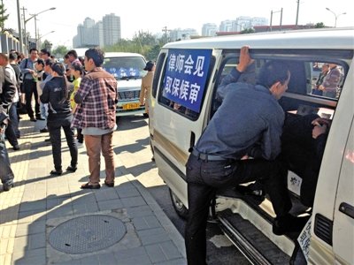 昨日，朝陽區(qū)看守所門前有人排隊(duì)。大門外還停有多輛寫有“律師會(huì)見”字樣的車。