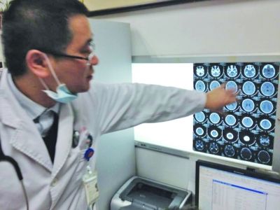 醫(yī)生在查看男孩的腦部CT片。薛馬義 攝