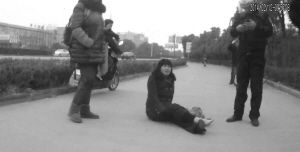 鄭大姐坐在地上，警方趕到進行施救。（視頻截圖由警方提供）