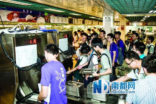 昨日，華南理工大學(xué)一食堂內(nèi)，學(xué)生們正在使用新安裝的自動(dòng)打飯機(jī)打飯。中新社發(fā)