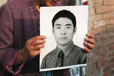 5月19日，朝陽(yáng)北路，母親捧著張東文的遺像。新京報(bào)記者 侯少卿 攝