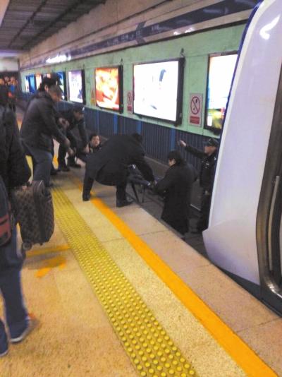 地鐵工作人員將林某從站臺下救起。網(wǎng)友供圖