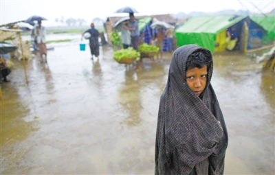 5月14日，緬甸若開邦實兌難民營，羅興亞族難民在雨中行走。熱帶風(fēng)暴“馬哈森”即將登陸緬甸，這里的難民開始乘船撤離。