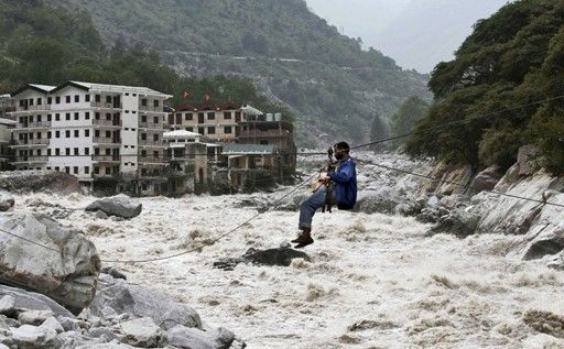 一名印度男子靠繩索渡河。
