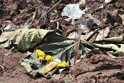 失事現(xiàn)場(chǎng),有人擺上鮮花放上香燭表示悼念。