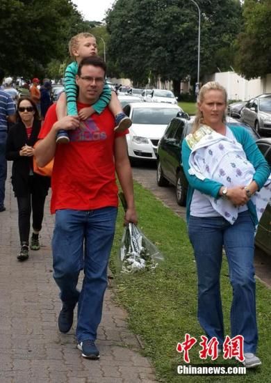 圖為一個(gè)白人家庭，由父母帶著孩子到曼德拉家門外悼念。中新社發(fā) 宋方燦 攝