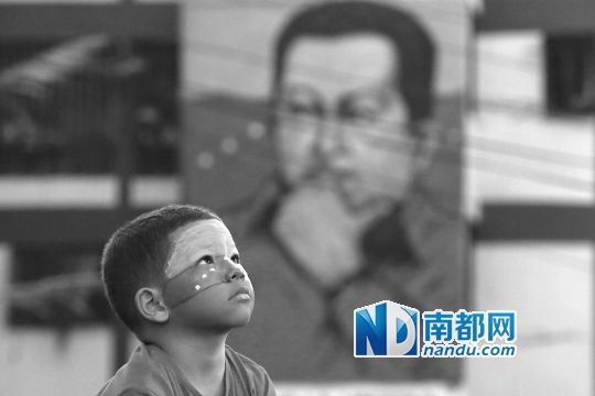 3月5日，一名委內(nèi)瑞拉兒童仰望天空，他身后是查韋斯的陵墓。